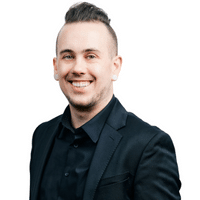 Professional portrait of Jerrid Boutto from the Arvold Mortgage Team, smiling in a black suit, emphasizing expertise in mortgage services related to refinancing and rate alerts.