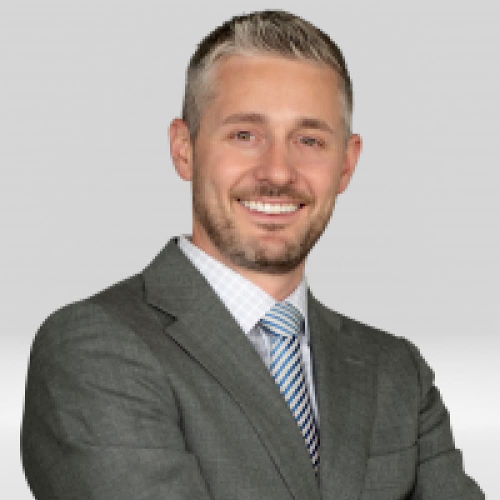 John Kinkeade, Mortgage Branch Manager at Refined Lending, smiling in professional attire, with a light gray background.