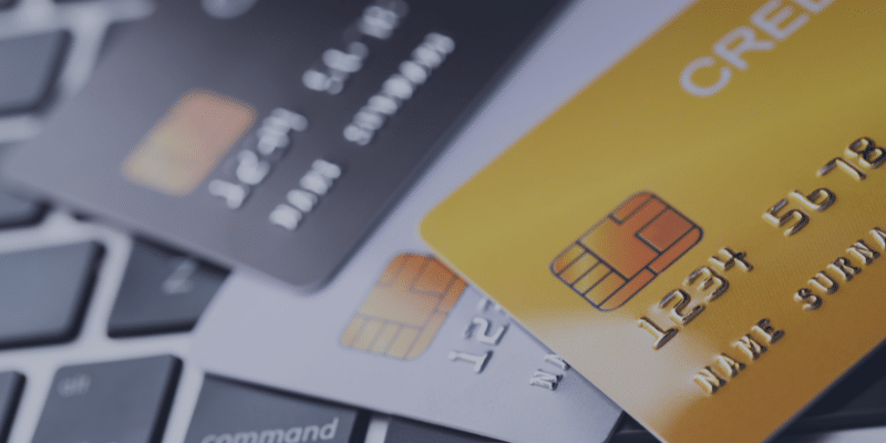 Credit cards on a laptop keyboard, emphasizing financial tools for mortgage qualification and credit score improvement.